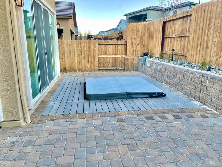 Paver courtyard bordered by a block retaining wall