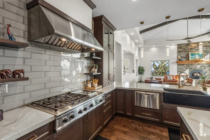 Range and patterned backsplash with light-colored cabinetry