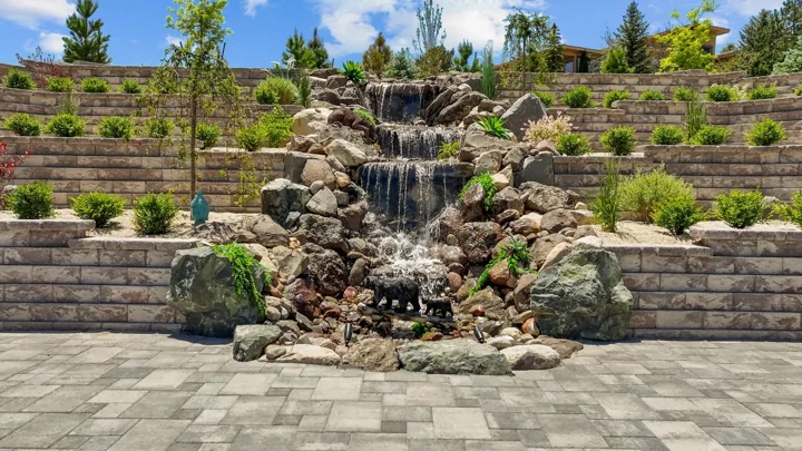 Terraced block retaining walls with a waterfall and planting